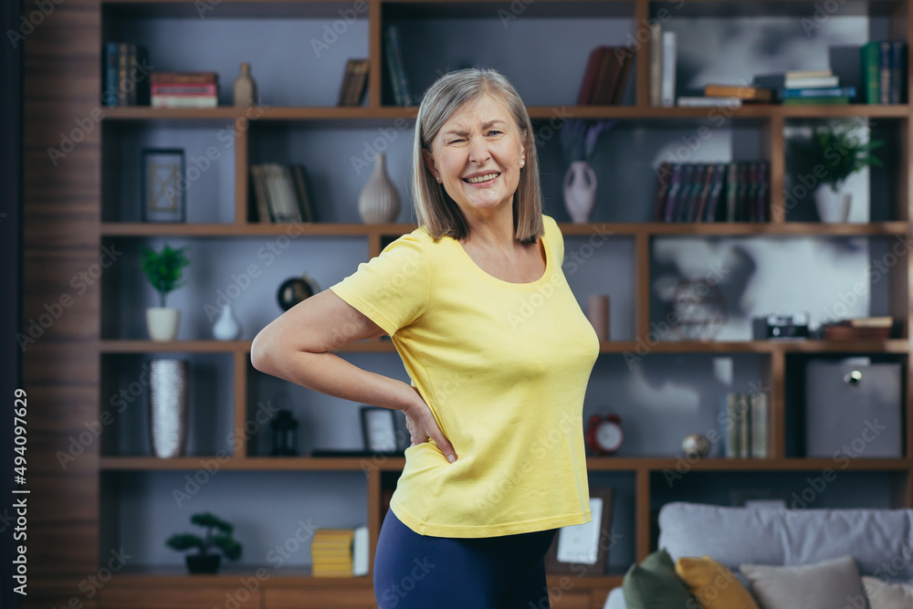 An older woman has severe pain in the abdomen after exercising at home An older woman has severe pain in the abdomen after exercising at home