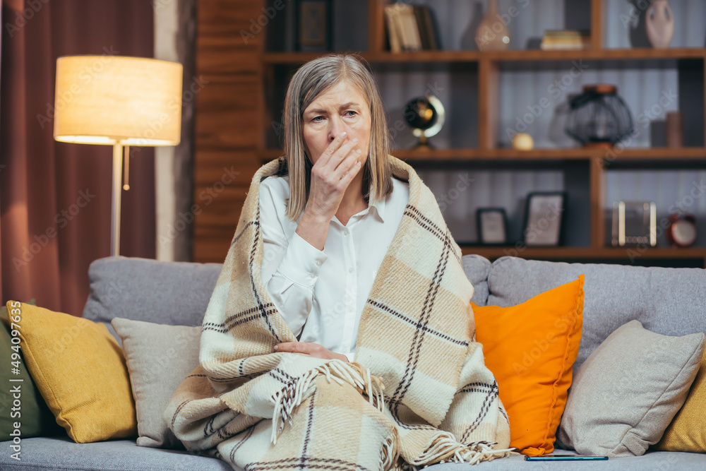 Sad gray-haired senior woman alone at home, crying depressed sitting on sofa Sad gray-haired senior woman alone at home, crying depressed sitting on sofa