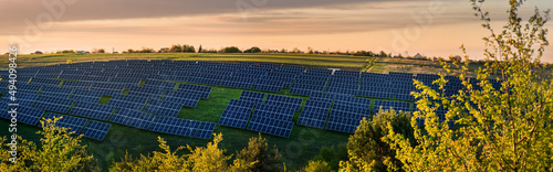 large solar panel station on the hills under the evening sky on landscape fro...