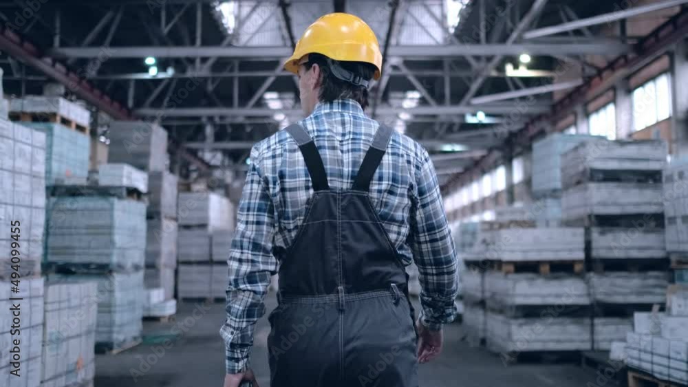 Worker male warehouse worker engineer man in a helmet working on the construction site of the warehouse, tablet computer, checking the warehouse, inspection of goods Worker male warehouse worker engineer man in a helmet working on the construction site of the warehouse, tablet computer, checking the warehouse, inspection of goods