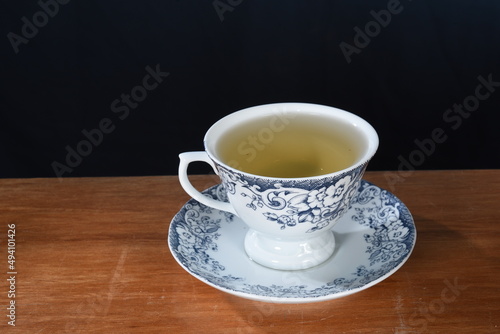 cup with lemongrass green tea  fine herbs cinnamon old crockery in the background