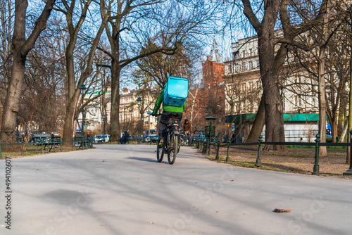 Wallpaper Mural A courier on a bicycle delivers food in the city in early spring Torontodigital.ca
