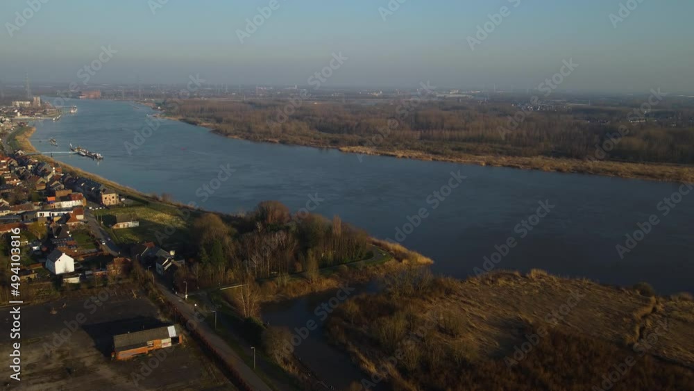 Majestic river Scheldt with small town and green surroundings, aerial fly towards Majestic river Scheldt with small town and green surroundings, aerial fly towards