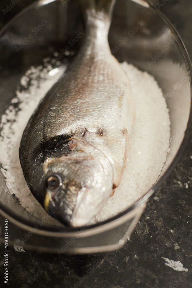Sea bream in a bowl with salt