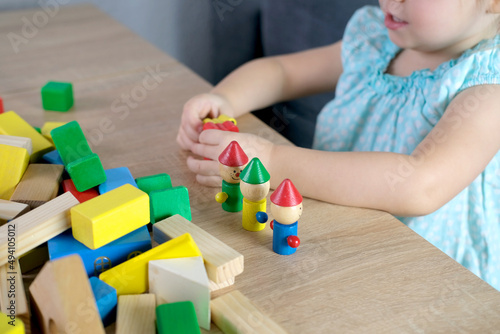 small child, a 2-year-old girl builds houses for characters from color blocks, the concept of childhood, earlier child development, creativity