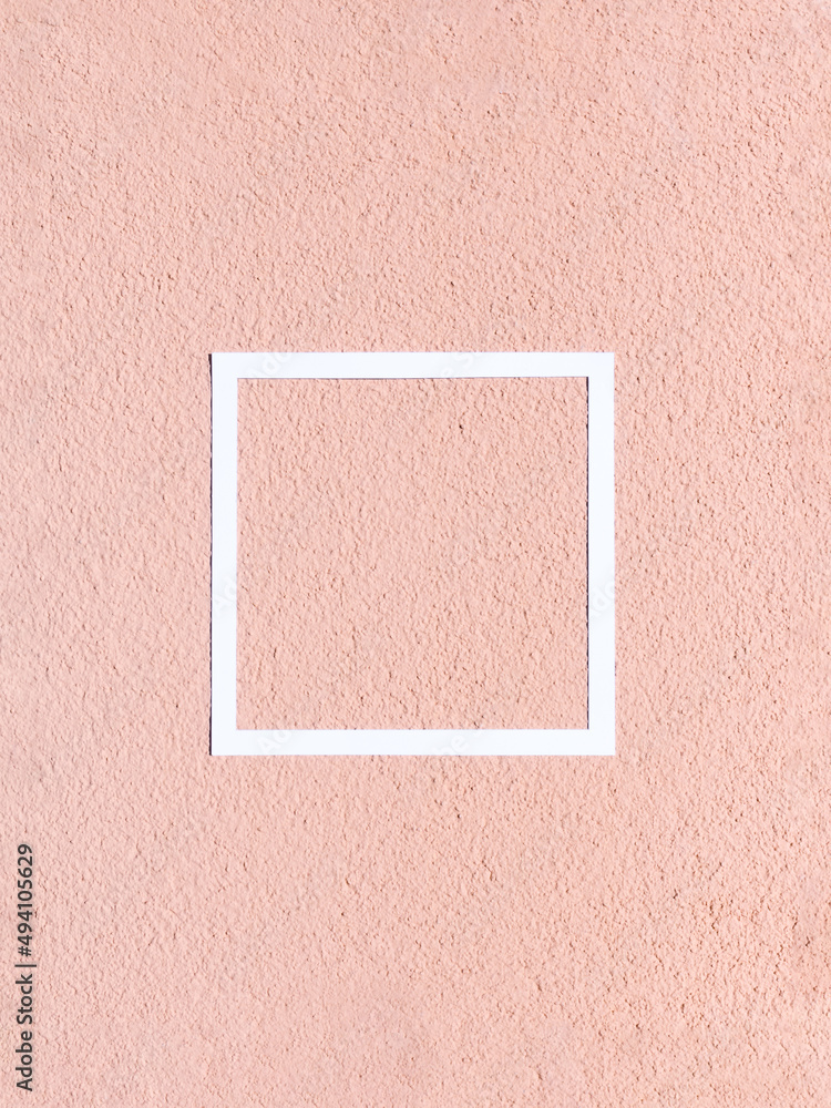 Fototapeta premium Facade of coarse fraction with grain texture painted in yellow/pink color with white frame. Minimal concept. Copy space.