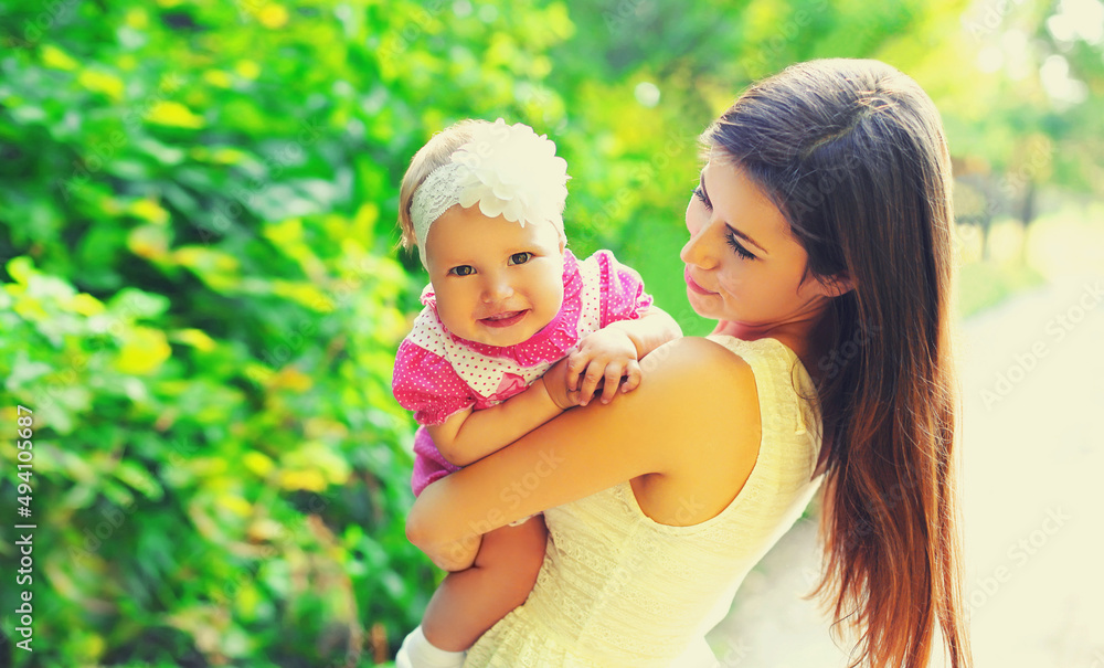 Portrait of happy young mother and little baby walking outdoors in summer park Portrait of happy young mother and little baby walking outdoors in summer park