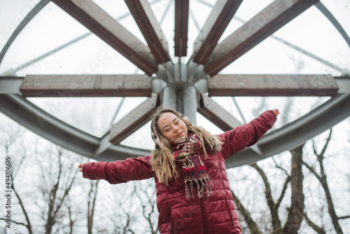 Happy young woman with Down syndrome listening to music in town in winter photo