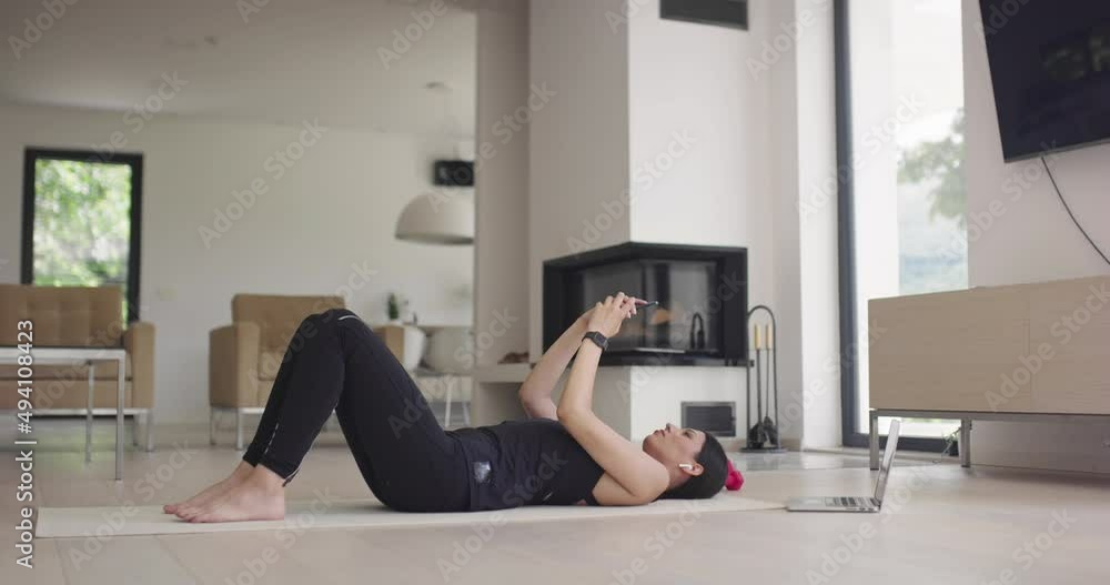 Beautiful Girl Using Smartphone after Fitness Workout at Home. Determined Plus Size Woman Using Fitness Tracker, Yoga Exercises Application, Browsing Online Health Articles, Posting on Internet Beautiful Girl Using Smartphone after Fitness Workout at Home. Determined Plus Size Woman Using Fitness Tracker, Yoga Exercises Application, Browsing Online Health Articles, Posting on Internet