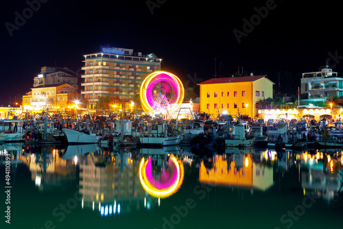 Cattolica town in the night . Italian coastal town illuminated in the nighttime . Ferris Wheel and harbor  photo