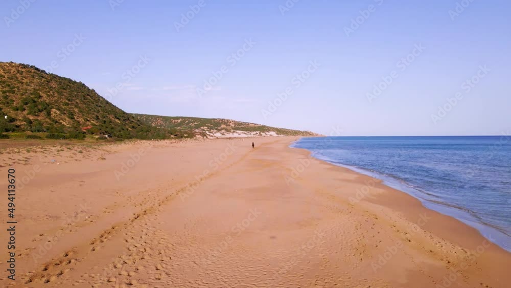 Aerial 4k man riding brown horse at natural sandy beach with crystal clear blue water and natural surrounding in Karpaz Peninsula, North Cyprus Aerial 4k man riding brown horse at natural sandy beach with crystal clear blue water and natural surrounding in Karpaz Peninsula, North Cyprus