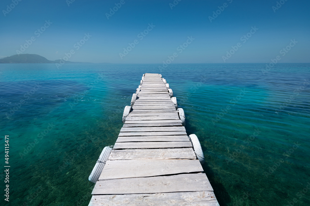 White old wooden pier on the seashore on a beautiful sunny day. Corfu Greece