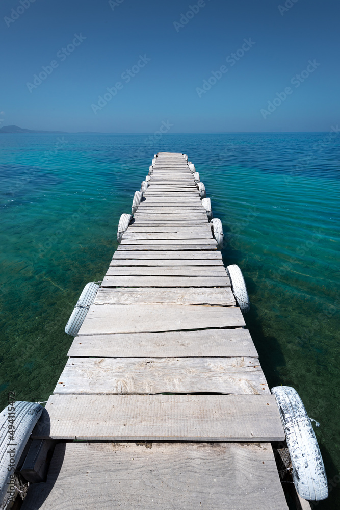 Beautiful white old wooden pier on the seashore on a beautiful sunny day. Corfu Greece
