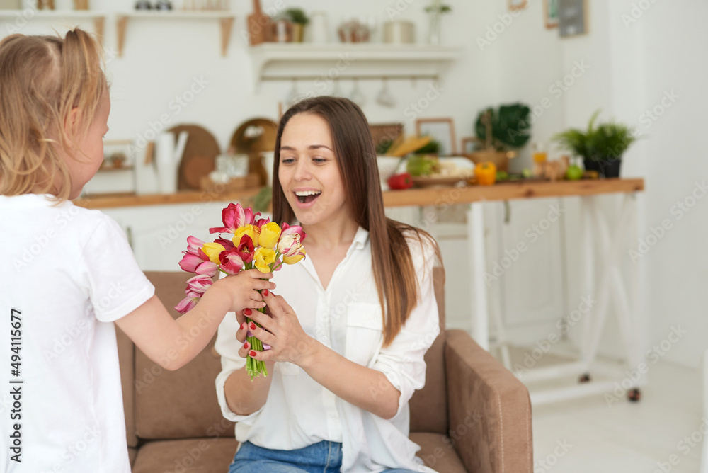 Happy mother accepts a gift from her little daughter. Congratulations on Mother's Day, birthday or Women's Day. Happy mother accepts a gift from her little daughter. Congratulations on Mother's Day, birthday or Women's Day.