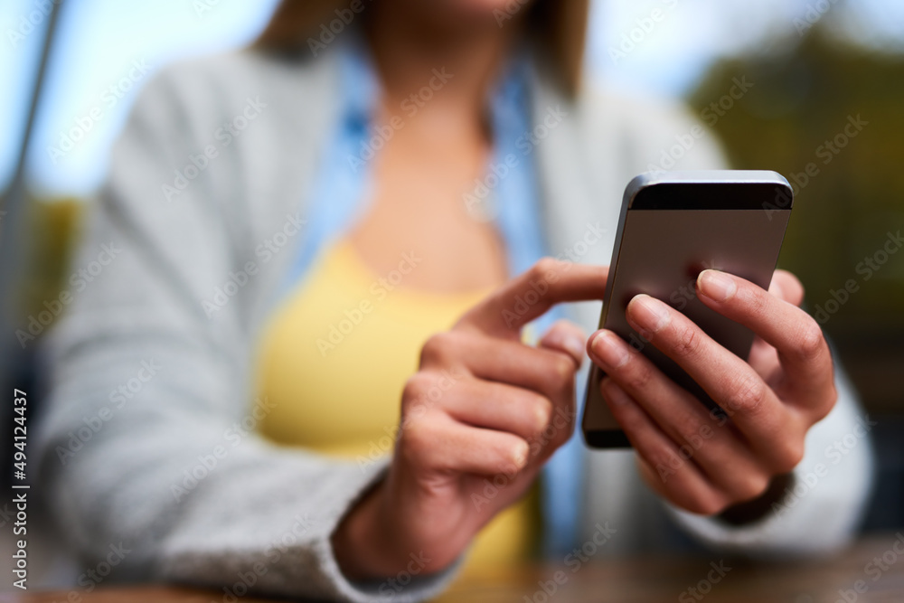 Stay in touch. Closeup shot of an unrecognizable woman texting on her cellphone.