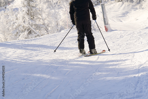 Skier in mountains, prepared piste and sunny day. winter, leisure, sport and people concept. Skier skiing downhill in mountains.