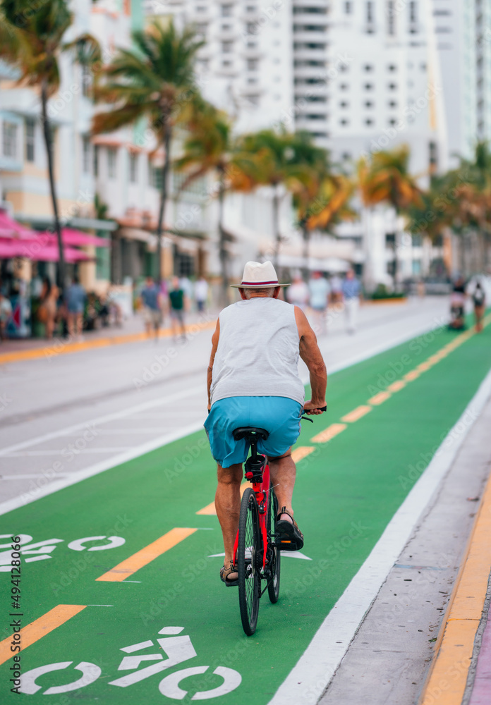 Obraz premium old man on bike ocean drive Miami Beach florida sport lifestyle road street