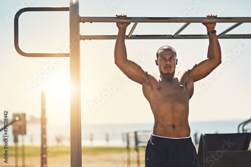 Aspiring to greater heights. Portrait of a young sporty man exercising outside. photo