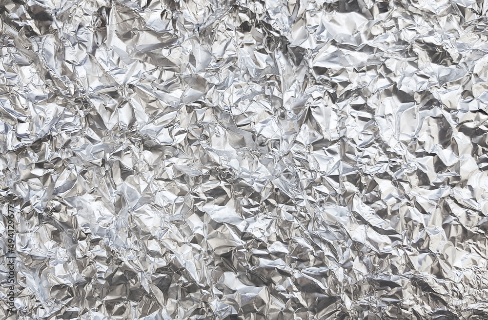 Silver foil with shiny crumpled surface texture background Silver foil with shiny crumpled surface texture background