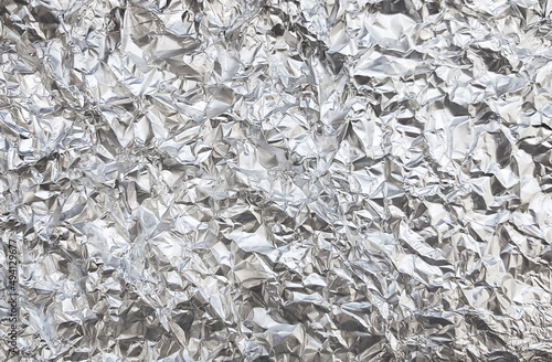 Silver foil with shiny crumpled surface texture background