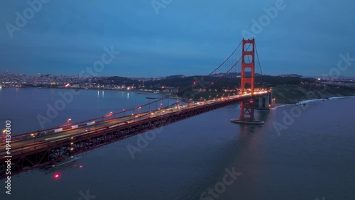 Establishing aerial San Francisco Skyline and illuminated red Golden Gate Bridge photo