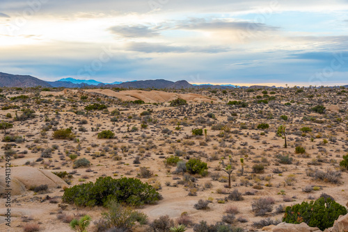 Sparse and remote landscape in the Californian desert during sunset with clouds starting to build color. 