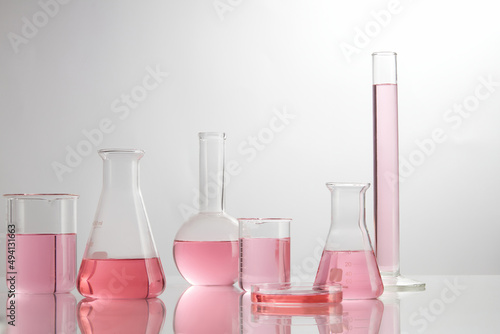 Front view of laboratory equipment filled with pink fluid in a beaker test tube in lab background for experiment advertising  photo