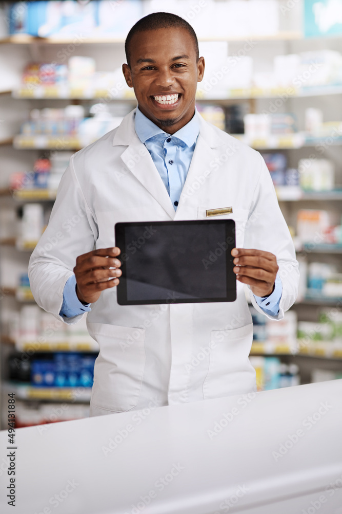 These are our top sellers. Portrait of a young pharmacist holding up a digital tablet with a blank screen in a chemist.