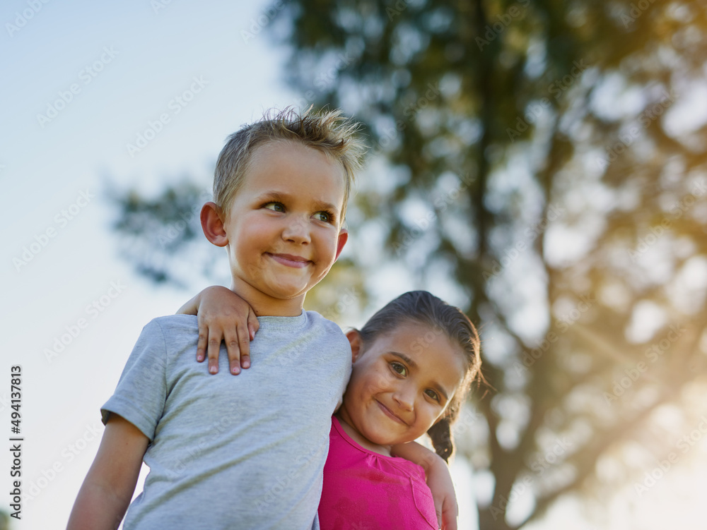 Siblings and best friends. Shot of a little brother and sister walking arm and arm together in a park. Siblings and best friends. Shot of a little brother and sister walking arm and arm together in a park.
