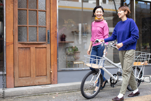 おしゃべりしながら街を歩くミドル世代の日本人女性2人 photo