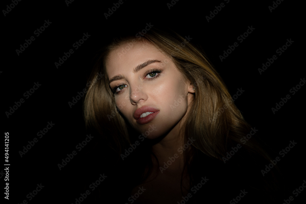 Sexy gorgeous woman with shadows on beautiful face on black studio. Beautiful female face in the darkness. Sexy gorgeous woman with shadows on beautiful face on black studio. Beautiful female face in the darkness.
