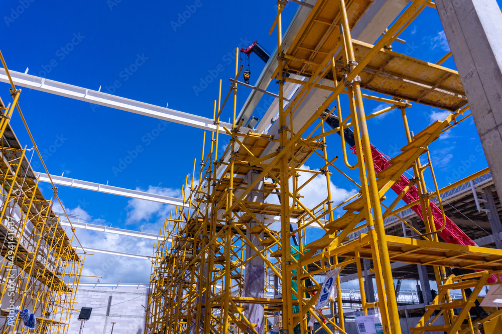 building construction site with yellow scaffolding , Installation Roof Steel structure