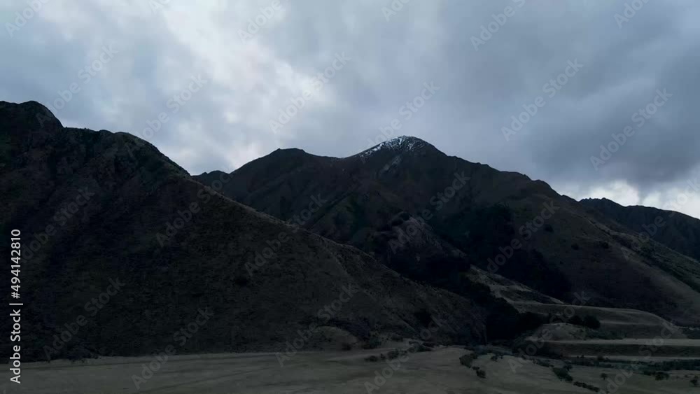 Aerial drone shot of a rocky mountain with dead brown grass, cloudy dark day in Moke, New Zealand. Orbit around a hill with a dark cloudy sky, 4K. Aerial drone shot of a rocky mountain with dead brown grass, cloudy dark day in Moke, New Zealand. Orbit around a hill with a dark cloudy sky, 4K.