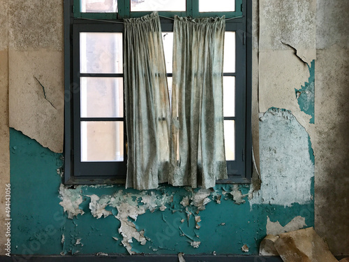 Tattered old curtains across the window of a room in an abandoned warehouse photo