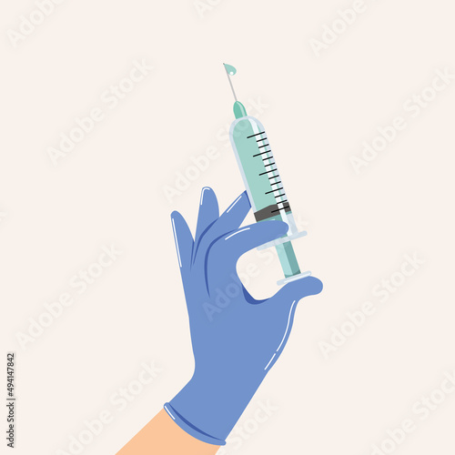 Hand in medical glove and holding syringe.
