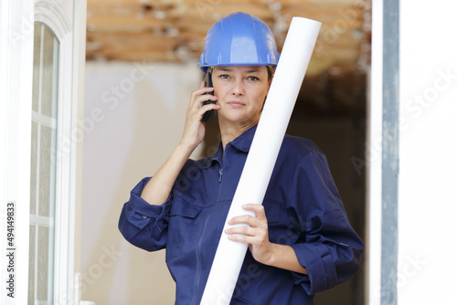 young happy woman builder on the phone