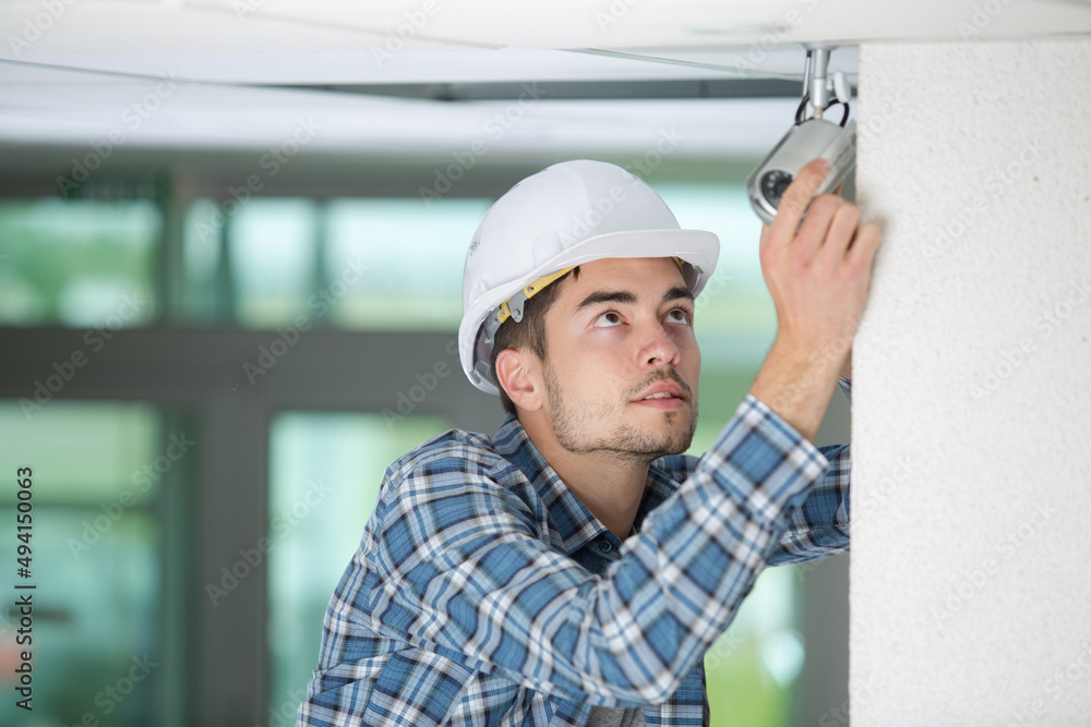 technician worker installing video surveillance camera on wall technician worker installing video surveillance camera on wall