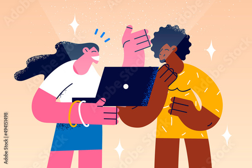 Smiling diverse girls use laptop together 