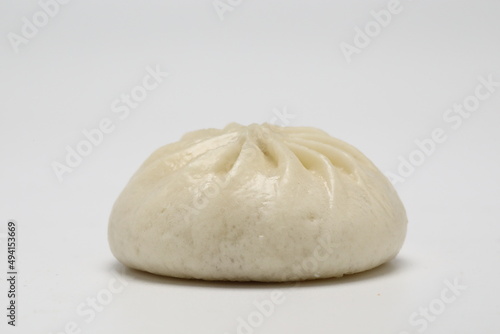 Delicious baozi, Chinese steamed meat bun is ready to eat on serving plate and steamer, close up, copy space product design concept.