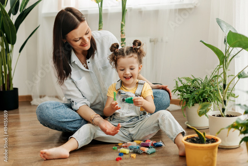 Mom and little daughter at home sculpt from plasticine and play together. The concept of preschool or home education