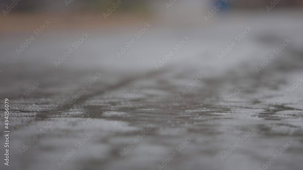 Damp Weather Raindrops Splashing On Wet Concrete Pavement, Close Up Damp Weather Raindrops Splashing On Wet Concrete Pavement, Close Up
