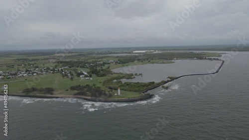 Burnett Heads Lighthouse At South Head Parklands With Burnett River At Its Mouth Into The Coral Sea. - aerial