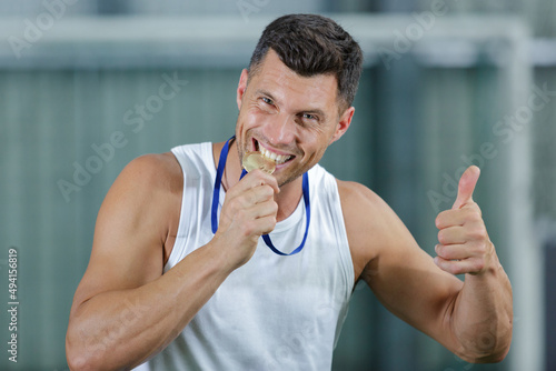 Fotografia closeup of handsome man biting his medal