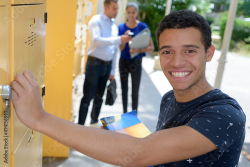 smiling male student at his locker