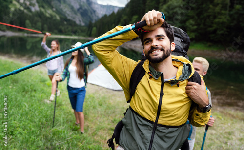 Group of smiling friends hiking with backpacks outdoors. Travel, tourism, hike and people concept.