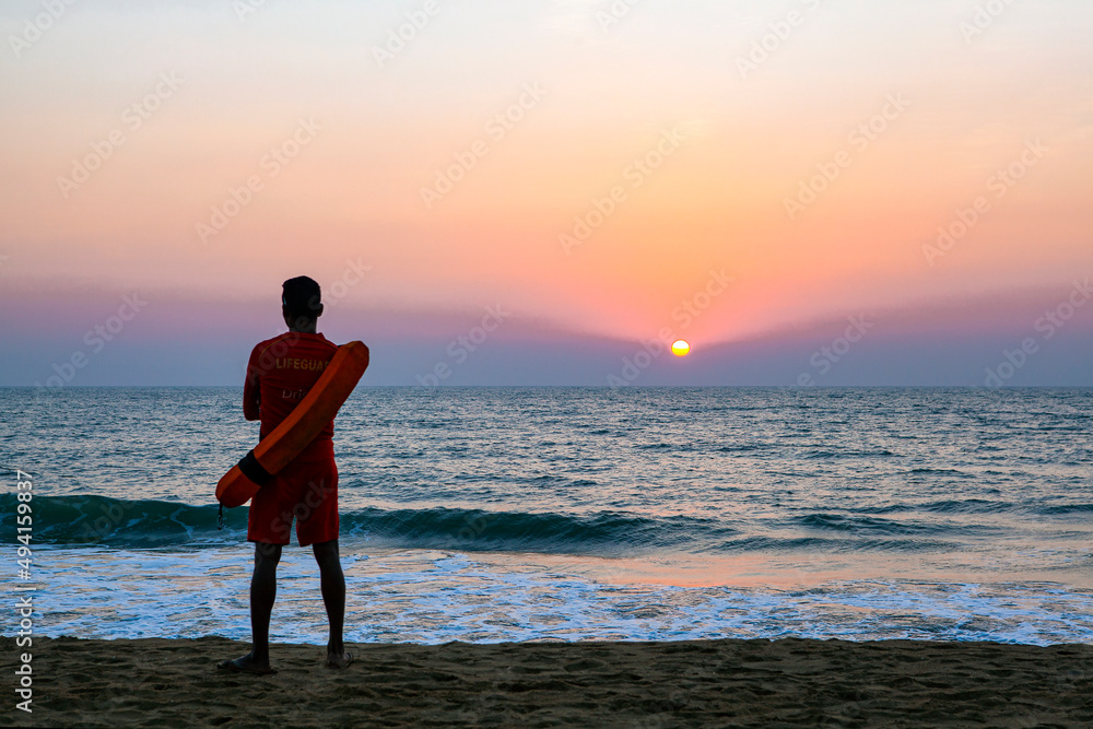 A lifeguard at sunset on the coast of Goa, India.