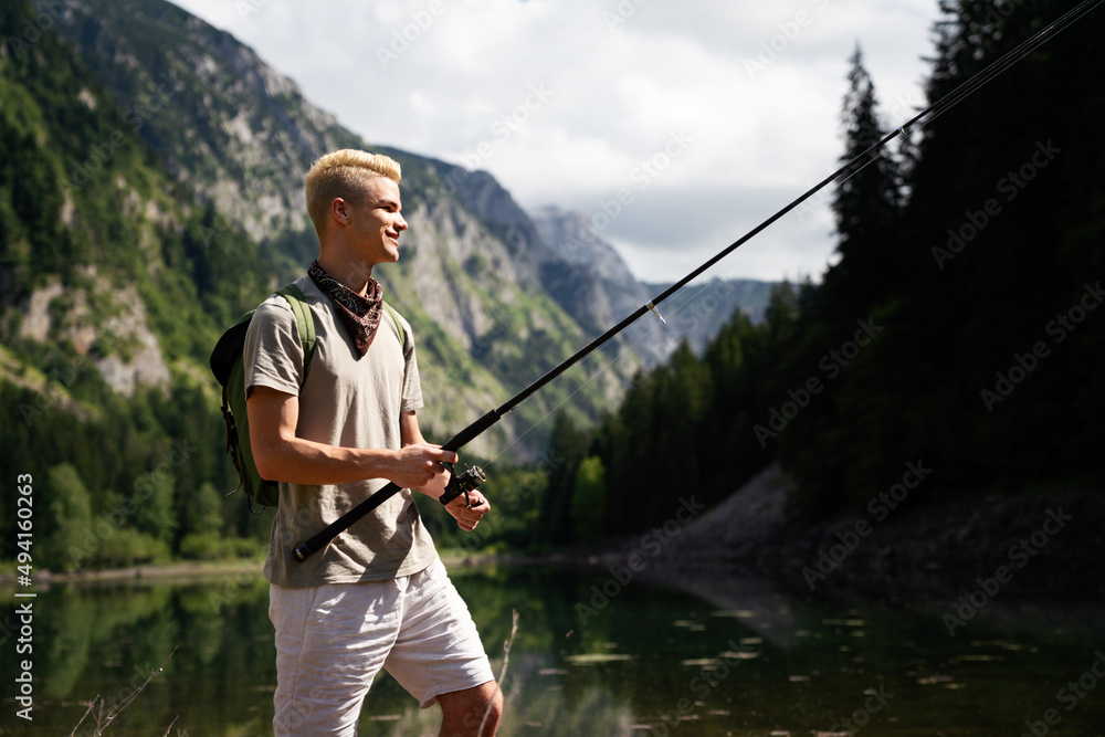 Fototapeta premium Fisherman fishing in nature at lake while camping outdoor