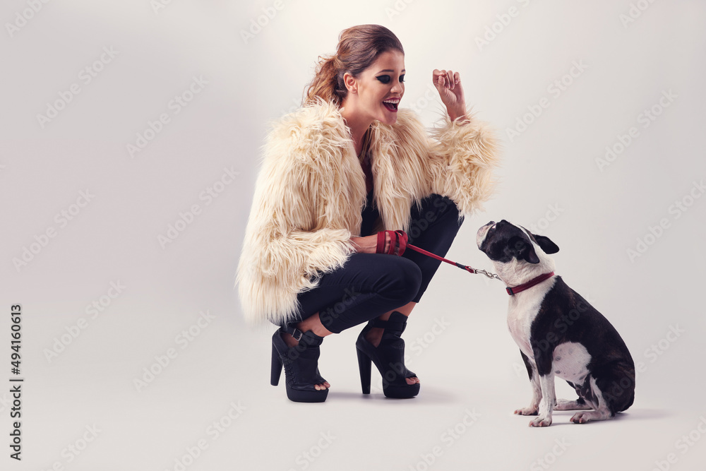 Thats a good boy. Studio shot of a young woman posing with her dog against a grey background. Thats a good boy. Studio shot of a young woman posing with her dog against a grey background.