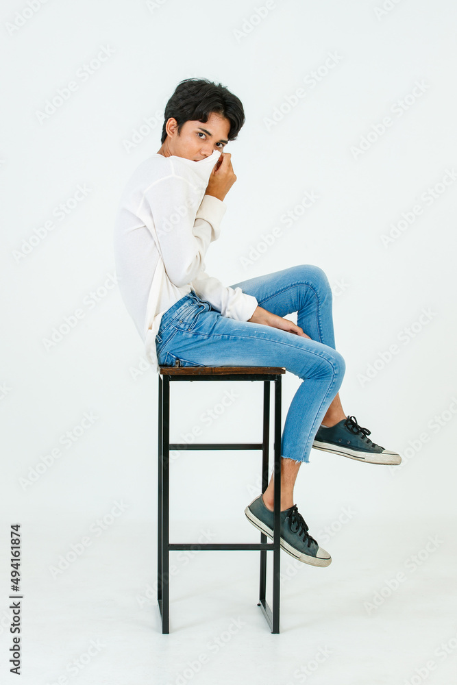 Portrait isolated studio shot Asian young LGBT gay happy handsome bisexual homosexual male fashion model in casual outfit sitting crossed legs on tall chair smiling look at camera on white background Portrait isolated studio shot Asian young LGBT gay happy handsome bisexual homosexual male fashion model in casual outfit sitting crossed legs on tall chair smiling look at camera on white background