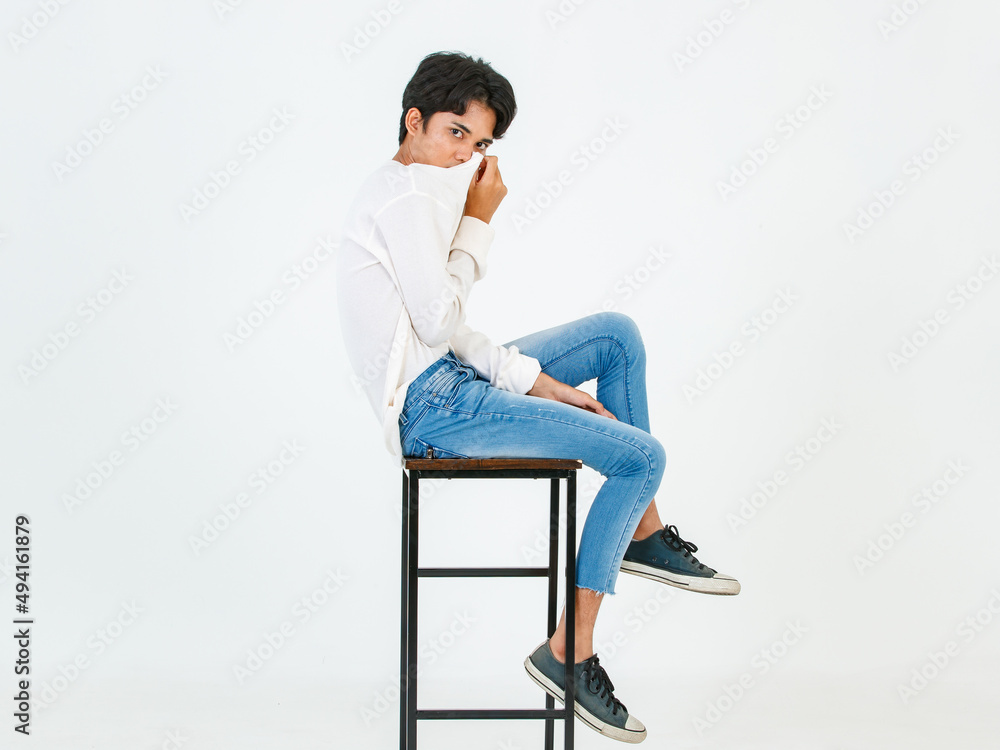 Portrait isolated studio shot Asian young LGBT gay happy handsome bisexual homosexual male fashion model in casual outfit sitting crossed legs on tall chair smiling look at camera on white background Portrait isolated studio shot Asian young LGBT gay happy handsome bisexual homosexual male fashion model in casual outfit sitting crossed legs on tall chair smiling look at camera on white background